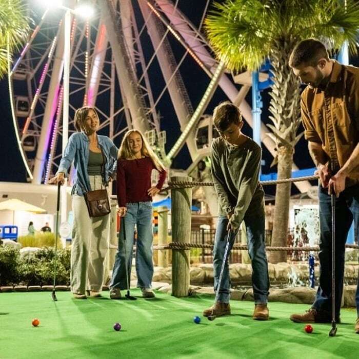 image of the family enjoying a round of mini golf